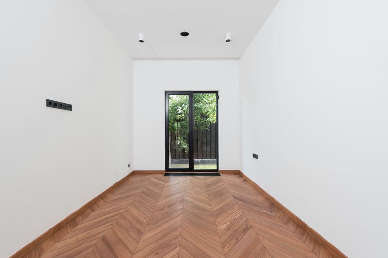 Finished room with herringbone timber floor and white walls